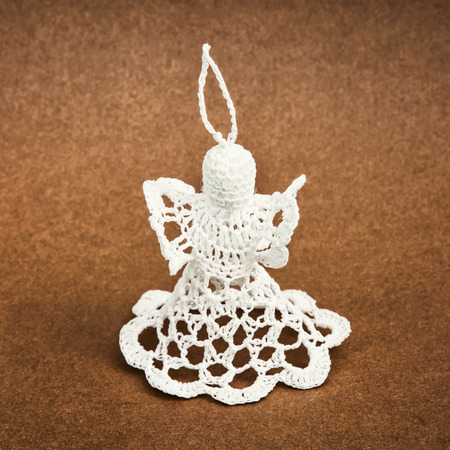 White crochet christmas angel on the brown background. Decorative product.の写真素材