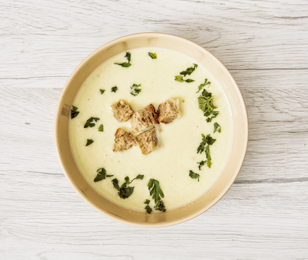 Leek soup with parsley and pieces of toasted bread on the wooden background. Food theme.の写真素材