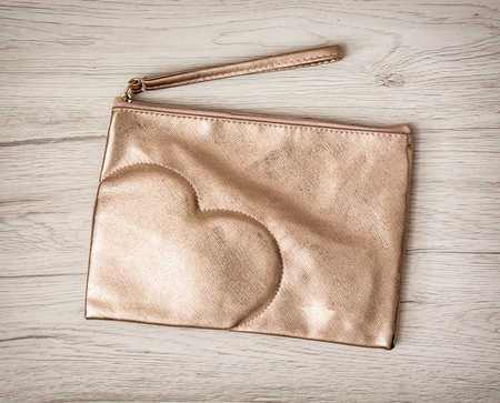 WomenÂ´s luxury necessary cosmetic bag with heart on the wooden background.の写真素材