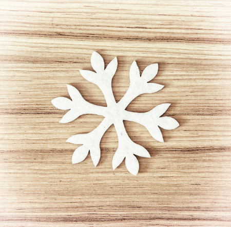 White snowflake on the wooden background. Symbol of winter.の写真素材