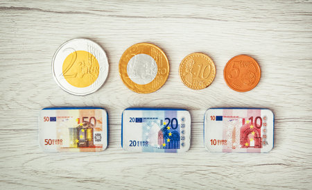 Chocolate money on the wooden background. Euros and cents. Banknotes and coins.