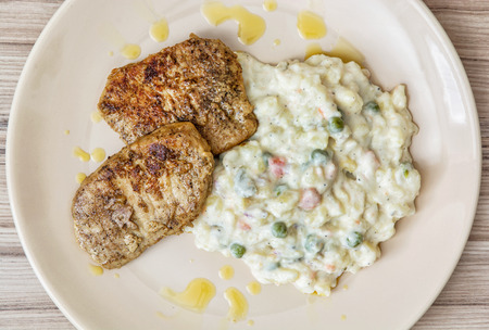 Roasted tenderloin of pork with mayonnaise potato salad on the plate. Food theme.の写真素材