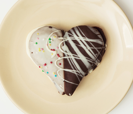 Tasty decorative gingerbread heart on the yellow plate. Sweet food. Tasty cookie.の写真素材