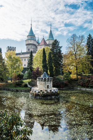 Bojnice castle with beautiful turret reflected in the lake, Slovak republic. Seasonal scene. Vertical composition.のeditorial素材