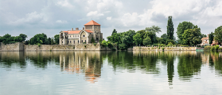 Beautiful castle with greenery and cloudy sky in Tata, Hungary. Travel destination. Architectural theme. Beautiful place. Fortress is reflected in the lake.のeditorial素材