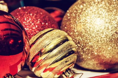 Red and yellow shimmering christmas baubles. Symbolic objects. Retro photo filter. Xmas decoration.の写真素材