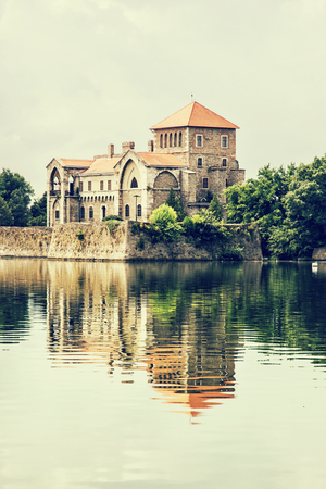 Beautiful castle in Tata, Hungary. Travel destination. Architectural theme. Beautiful place. Fortress is reflected in the lake. Retro photo filter. Vertical composition.のeditorial素材