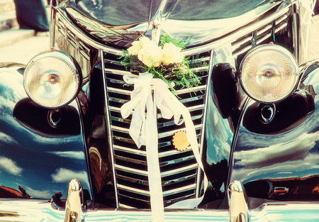 Front view of historical wedding car with ribbon and flowers. Symbol of love.の写真素材
