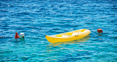 Anchored yellow kayak in Maslinica, Solta island, Croatia. Summer vacation destination.の写真素材