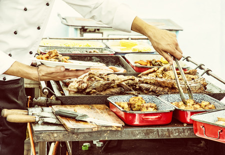 Masterchef serves grilled meat. Detail food and hands scene. Feast theme. Yellow photo filter.の写真素材