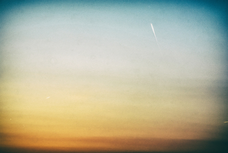Sunset beautiful colorful twilight in pure sky with airplanes. Evening scene. Analog photo filter with scratches.の写真素材