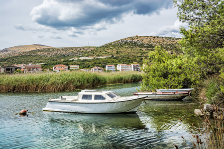 Boats with reflections in the beach bay, Pantan, Trogir, Croatia. Summer vacation destination.の写真素材
