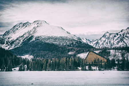 Solisko peak and hotel Patria in Strbske pleso, High Tatras, Slovak republic. Winter mountains. Travel destination. Analog photo filter with scratches.のeditorial素材