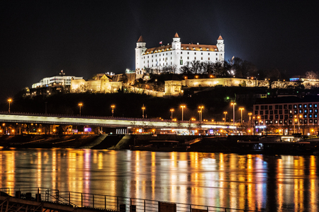 BRATISLAVA, SLOVAK REPUBLIC â NOVEMBER 18, 2018: Bratislava castle and SNP bridge is mirroring in Danube river, Slovak republic. Night photo. Travel destination. Illustrative editorial.のeditorial素材