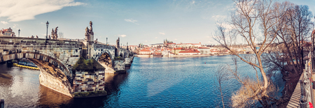 Charles bridge over Vltava river and beautiful castle in Prague, Czech republic. Travel destination. Panoramic photo. Red photo filter.のeditorial素材
