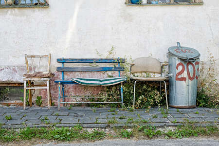 Wooden bench and chairs with metal garbage can, Lubietova, Slovak republic. Retro scene.の写真素材