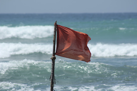 Red flag during a storm on the oceanの写真素材