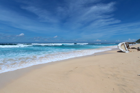 Broken boat lies on a Sandy Beachの写真素材