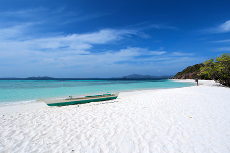 One boat on an empty sandy beach by the seaの写真素材
