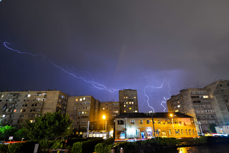 Lightning in the night sky over houses.