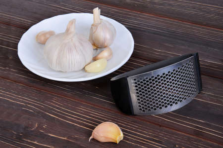 Garlic press and cloves of garlicの写真素材