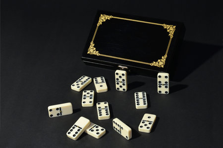 Black and white dominoes on a black background with a golden frame