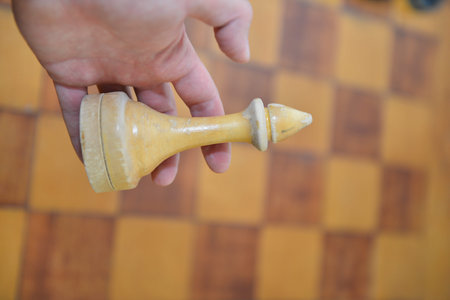 Chess game, hand with wooden chess piece on chessboard background