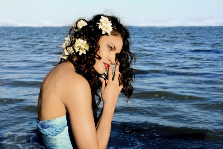 Girl with shells on the sea background の写真素材