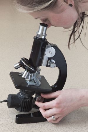 Woman looking through microscopeのeditorial素材