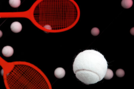 White tennis balls against a black background.