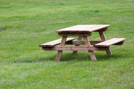 A set of table and benches on a grass background.の写真素材