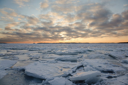 A winter landscape in the sunset with packed ice in the sea.