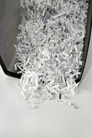 Shredded paper in black mesh waste basketの写真素材