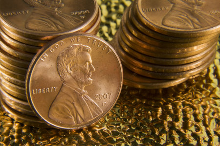 Stack of pennies against a gold background.