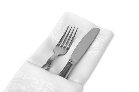 Flatware wrapped with a white linen napkin against a white backgroundの写真素材