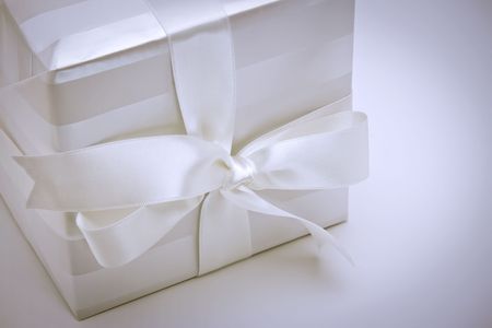 Blue toned white gift box tied with a white satin ribbon and bow.の写真素材