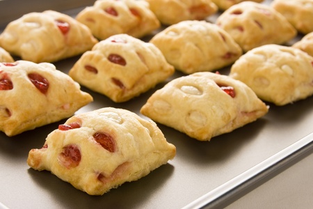 Strawberry strudel bites in rolls on a cookie sheet.の写真素材