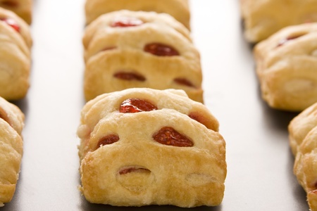 Strawberry strudel bites in rolls on a cookie sheet.の写真素材