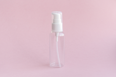 Empty jar for use on a travel on soft pink background. For all toiletries, shampoo, lotion, nail varnish remover and shower gels. Conception of care of female beauty of the face and body. A small thing which will always be located in a female handbag.の写真素材