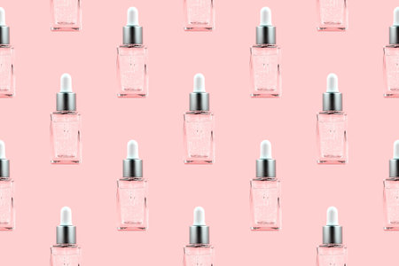 Seamless pattern of glass bottle with dropper with cosmetic serum, oil against pastel pink background.の写真素材