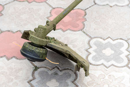Lawn mower repair. Manual lawn mower is defective. A string for cutting grass is over. Front view.の写真素材