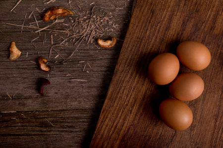four chicken organic eggs on cutting board with straw rustic wooden backgroundの写真素材