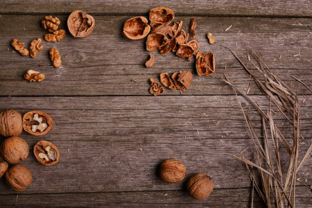 Walnuts on rustic background wooden board with straw copy space for text