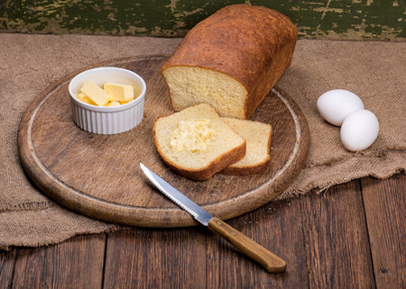 Sliced baked white bread on wooden board table still life
