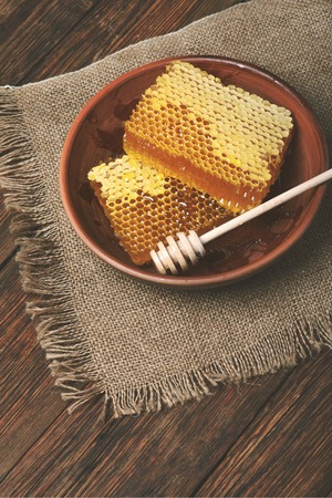 honey comb on a wooden table closeup, top viewの写真素材