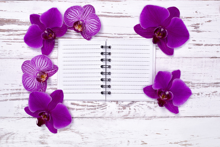 diary on old wooden table decorated with orchid flowersの写真素材