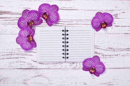 diary on old wooden table decorated with orchid flowersの写真素材