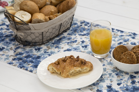 Continental breakfast with fresh croissants, biscuits, bread and orange juice on tableの写真素材