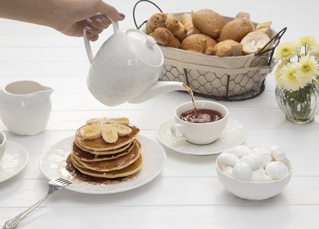 breakfast with pancakes and tea on tableの写真素材
