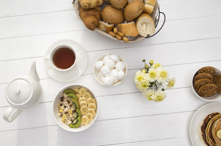 Breakfast with oatmeal porridge, coffee cup and fruits. Oatmeal with kiwi and banana. Healthy breakfast concept. Top viewの写真素材